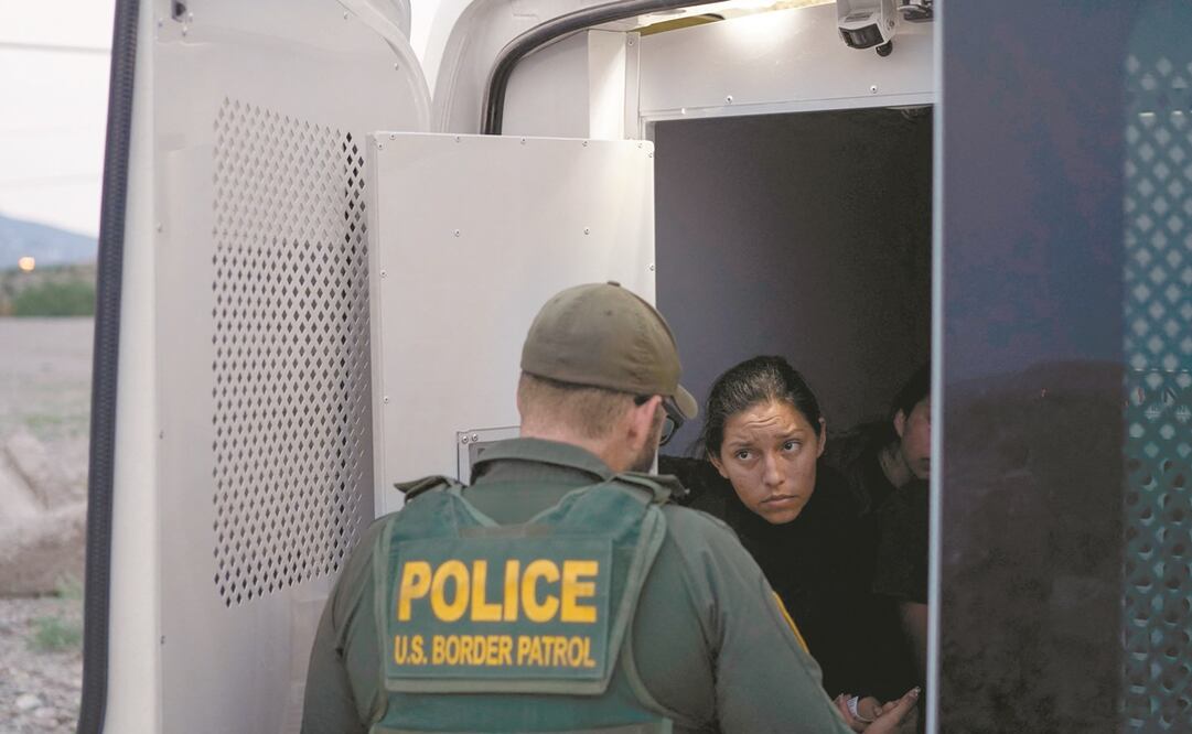 Una mujer detenida por cruzar la frontera entre EU y México, con un agente de la Patrulla Fronteriza, en Sunland Park, Nuevo México. Foto: Paul Ratje/ AFP.
