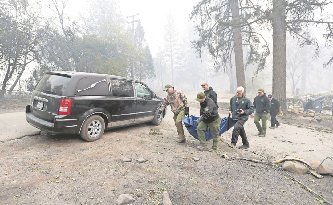 Autoridades cargan un cuerpo a una carroza, tras haberlo sacado ayer de una vivienda quemada en Paradise, California. Foto: JOSH EDELSON. AFP