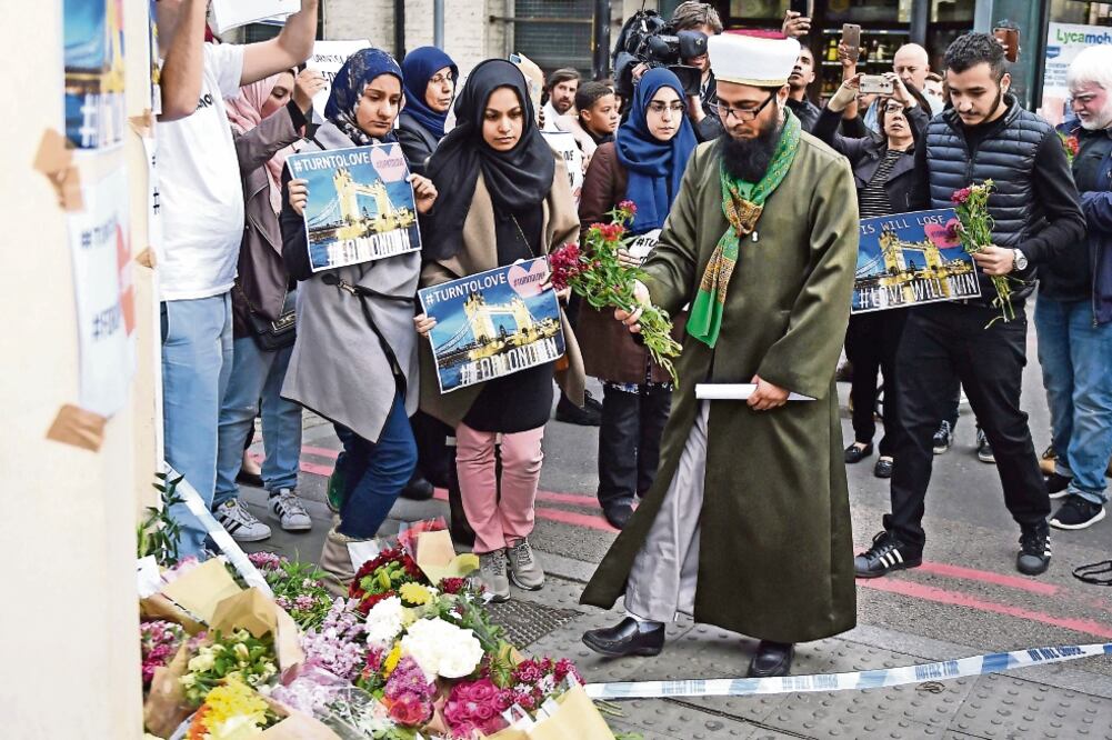 Miembros de la comunidad musulmana de Londres colocan flores en un memorial en honor a las víctimas del ataque registrado el sábado en esta ciudad (ANDY RAIN. EFE)