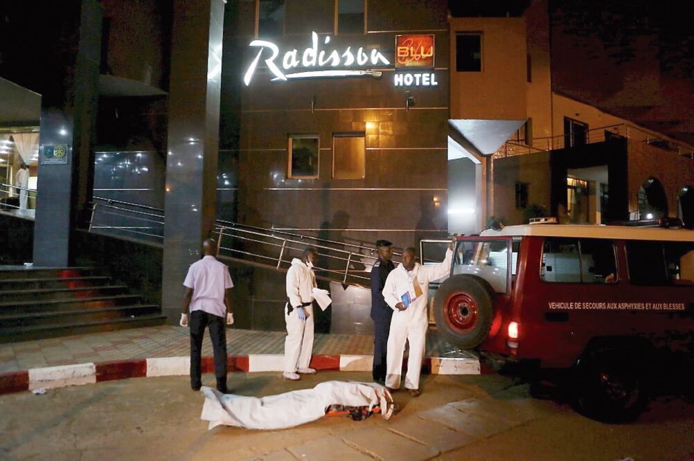 Funcionarios malienses se preparan para llevarse un cuerpo en un vehículo de emergencia, afuera del hotel Radisson Blu, en Bamako, donde islamistas se atrincheraron ayer durante varias horas con rehenes (JOE PENNEY. REUTERS)