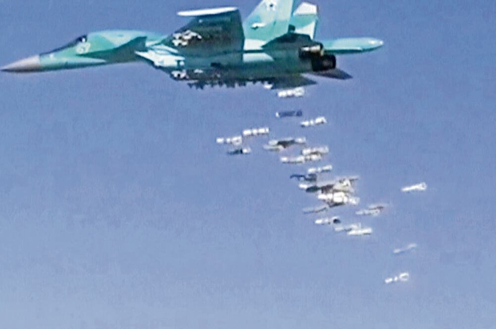 Imagen de la televisión rusa en la que se observa cómo un bombardero Sukhoi Su-34 arroja proyectiles sobre la provincia siria de Deir Ezzor (REUTERS)