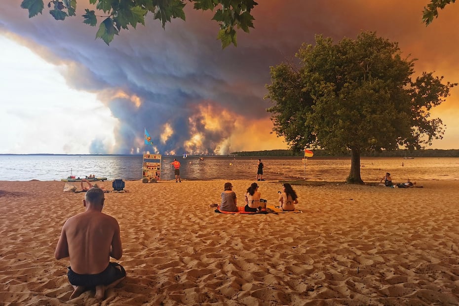 Bañistas en la playa de Moutchic, al suroeste de Francia, observan nubes de humo de un incendio que afecta la cuenca de Arcachón. FOTO: MAXIMILIEN LAMY. AFP)