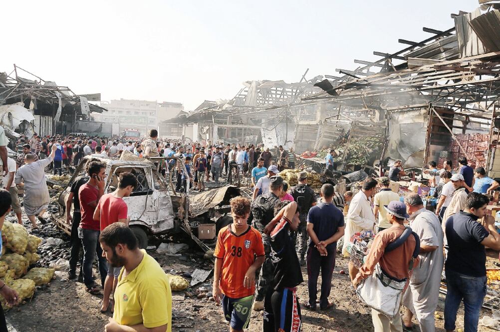 Iraquíes se reúnen en el lugar donde explotó un camión-bomba, ayer en el mercado de Jamila en Ciudad Sader, en Bagdad (KARIM KADIM. AP)