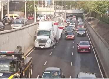 Tráiler se atora en bajo puente de Viaducto; remolque con 22 toneladas de arena para gato quedó destruido