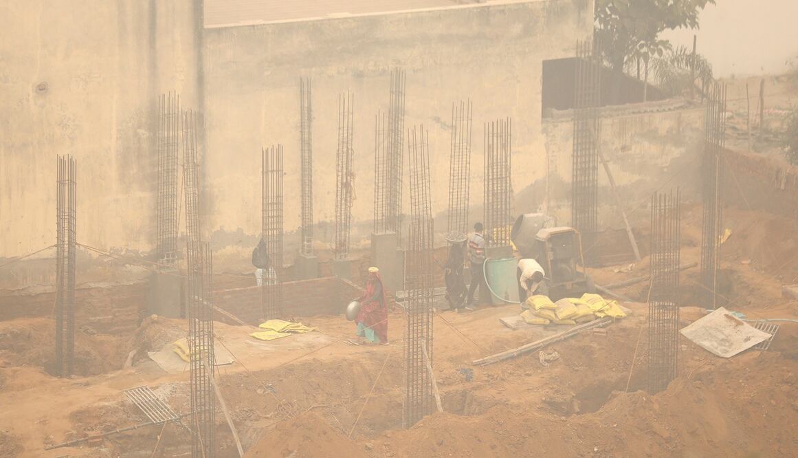 Obreros trabajan en una obra en medio de una densa niebla tóxica en Nueva Delhi, India. FOTO: EFE