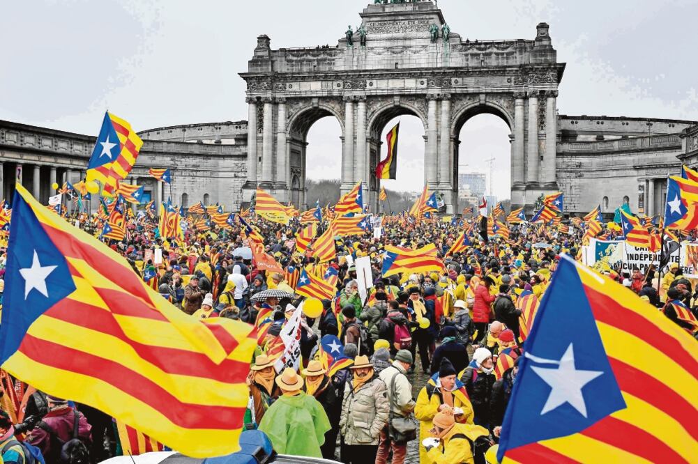 Manifestantes ondean banderas “Esteladas” durante el acto de ayer en Bruselas en favor de la independencia catalana. (AFP)