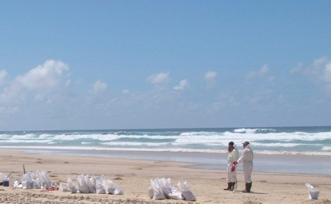 Voluntarios limpian los restos de marea negra en una playa de Moreton Island, en la costas de Queensland, Australia. Foto: Archivo