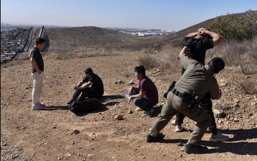 Migrantes son detenidos por la Patrulla Fronteriza tras cruzar el muro en San Diego, California. Foto: AP