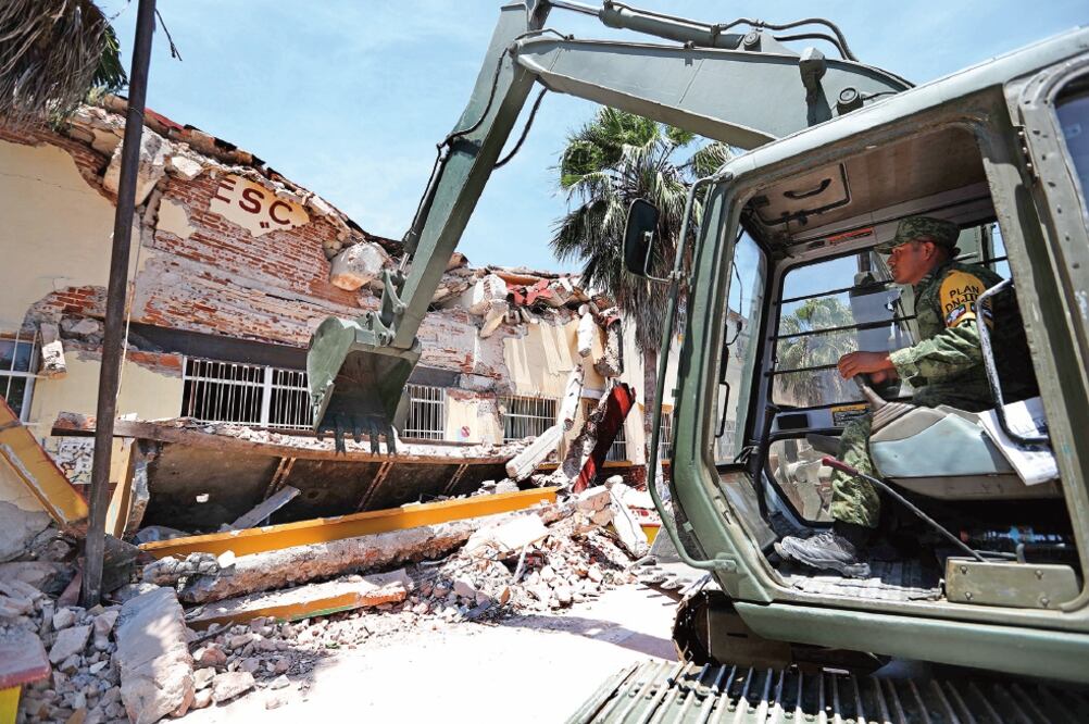 Soldados apoyados con maquinaria pesada comenzaron ayer por la tarde la demolición del Centro Escolar Juchitán, trabajos que tardarán un mes, estiman autoridades de la Secretaría de Educación Pública. (FOTOS: VALENTE ROSAS. EL UNIVERSAL)