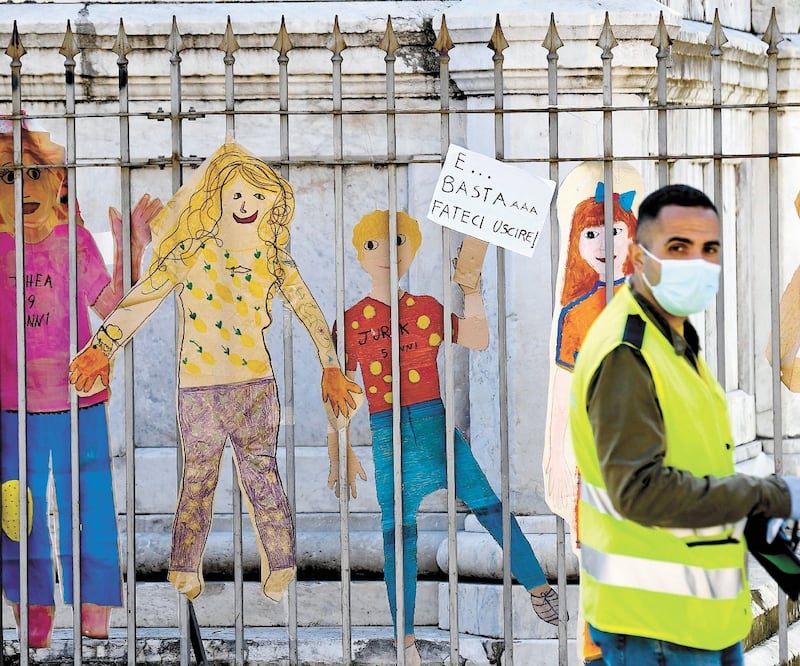Al pie de la estatua de Dante Alighieri, en Nápoles, Italia, han sido colocados dibujos y carteles criticando las medidas de encierro por el coronavirus. CIRO FUSCO. EFE