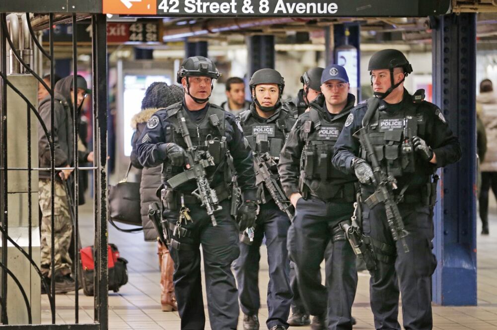 Policías patrullan los pasillos entre la terminal de autobús y el Metro de Nue va York, donde el lunes un hombre intentó cometer un ataque con explosivos. (SETH WENIG. AP)