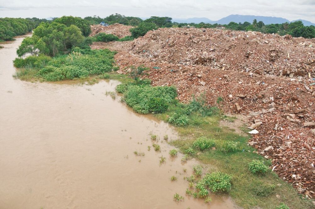 ONG denunció que el cementerio de escombro de las casas de Ixtaltepec lleva una altura de más de tres metros sobre el borde del río Los Perros, extendiéndose hasta 10 metros a los costados y más de 500 metros de largo rumbo a El Espinal (EDWIN HERNÁNDEZ)