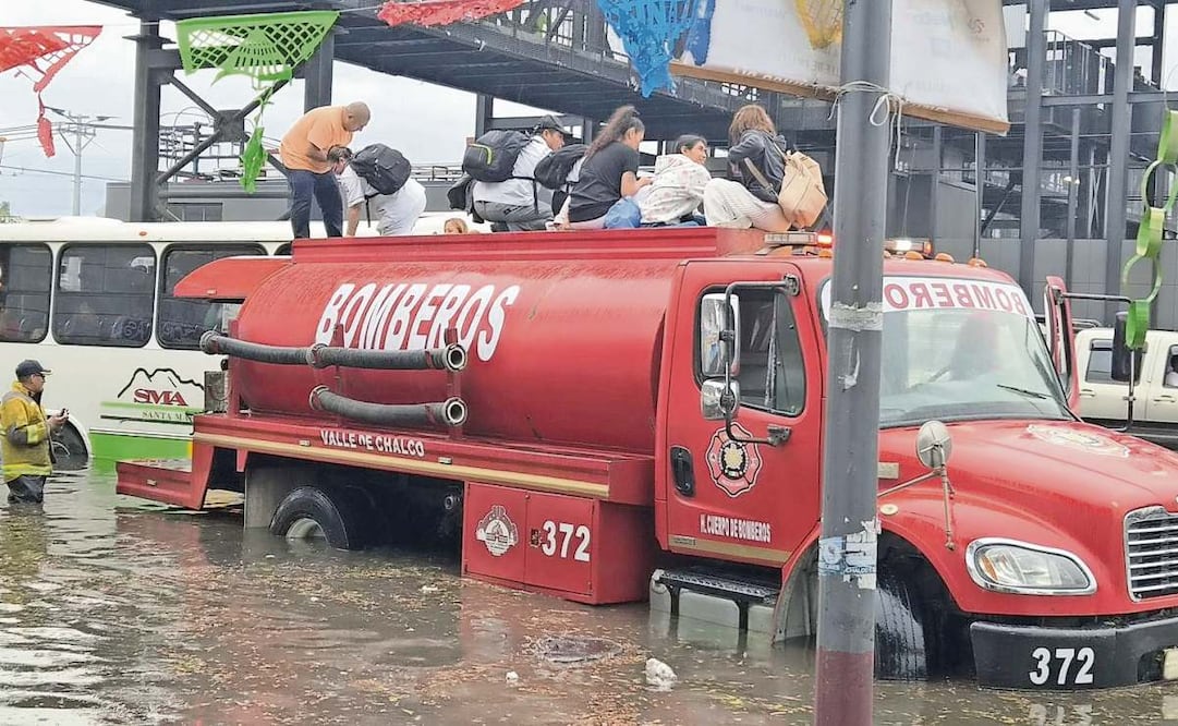Por las anegaciones en la carretera México-Puebla, usuarios del Trolebús debieron ser trasladados en vehículos de bomberos para sacarlos de la zona. Foto: Especial