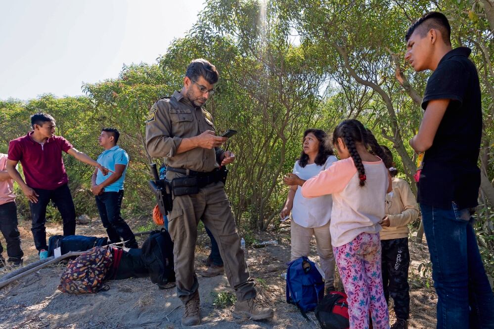 Agentes fronterizos, con migrantes que buscan asilo, mientras los preparan para llevarlos a ser procesados, cerca de Dulzura, California. Foto: Gregory Bull. AP