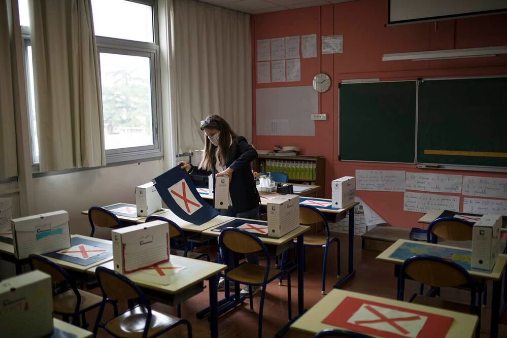 Sylvie Duquesnoy, directora de la escuela primaria Saint-Tronc Castelroc, prepara un aula para recibir a estudiantes que regresan a la escuela de forma voluntaria, en Marsella, en el sur de Francia, el 11 de mayo de 2020. (AP Foto/Daniel Cole)