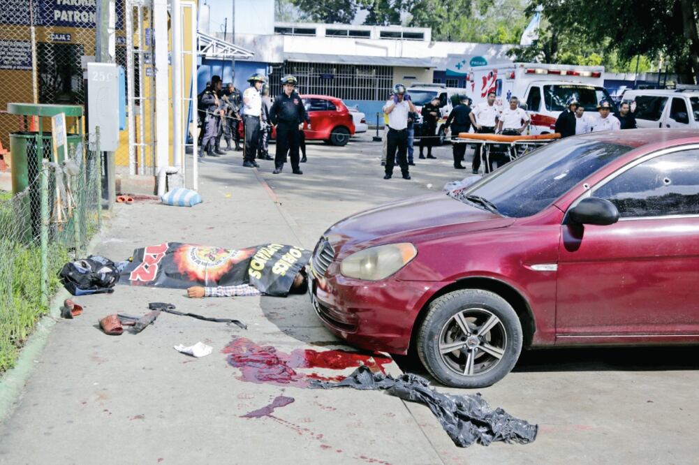 Un cuerpo yace junto a un rifle, tras el ataque de mareros en el Hospital Roosevelt de la capital guatemalteca. El objetivo, logrado, era rescatar a Anderson Daniel Cabrera Cifuentes, de la MS-13. (LUIS ECHEVERRÍA. REUTERS)