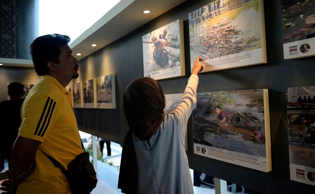 Gente mira fotografías del tsunami del Océano Índico durante la conmemoración del 20º aniversario del desastre. Foto: AP