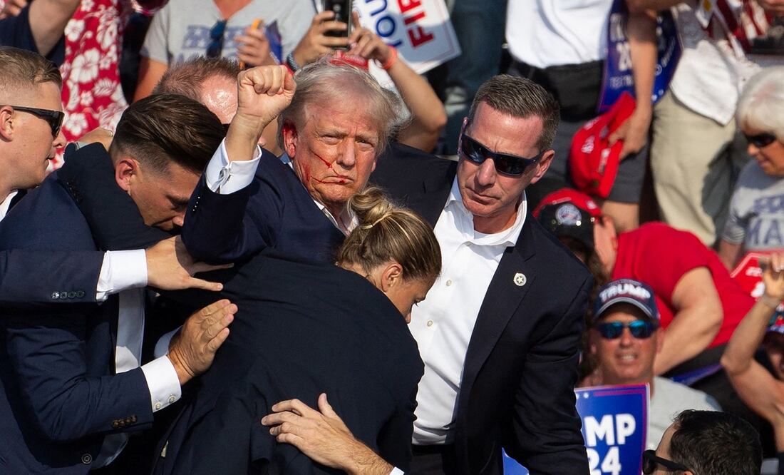 El virtual candidato presidencial republicano, Donald Trump, es protegiso por agentes del Servicio Secreto y su equipo de seguridad, tras ser atacado en un mitin en Butler, Pennsylvania, el 13 de julio de 2024. FOTO: REBECCA DROKE. AFP