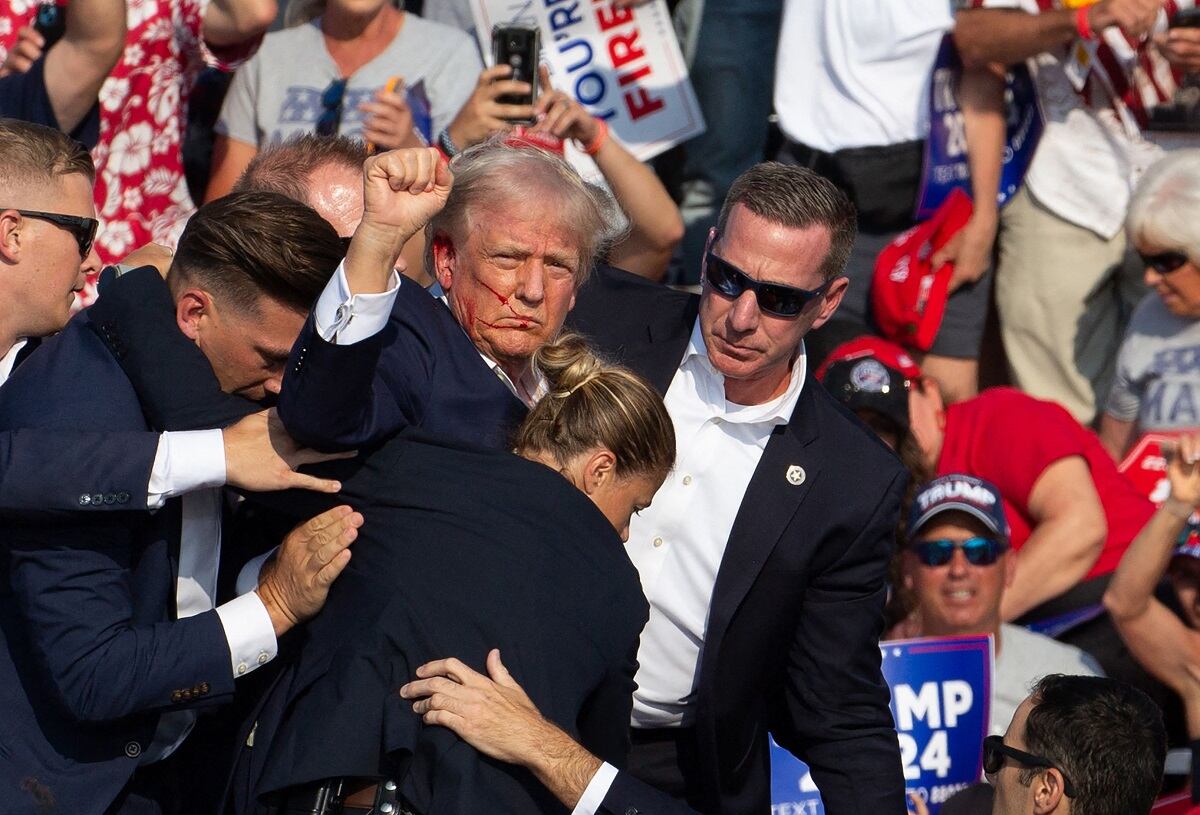 El virtual candidato presidencial republicano, Donald Trump, es protegiso por agentes del Servicio Secreto y su equipo de seguridad, tras ser atacado en un mitin en Butler, Pennsylvania, el 13 de julio de 2024. FOTO: REBECCA DROKE. AFP