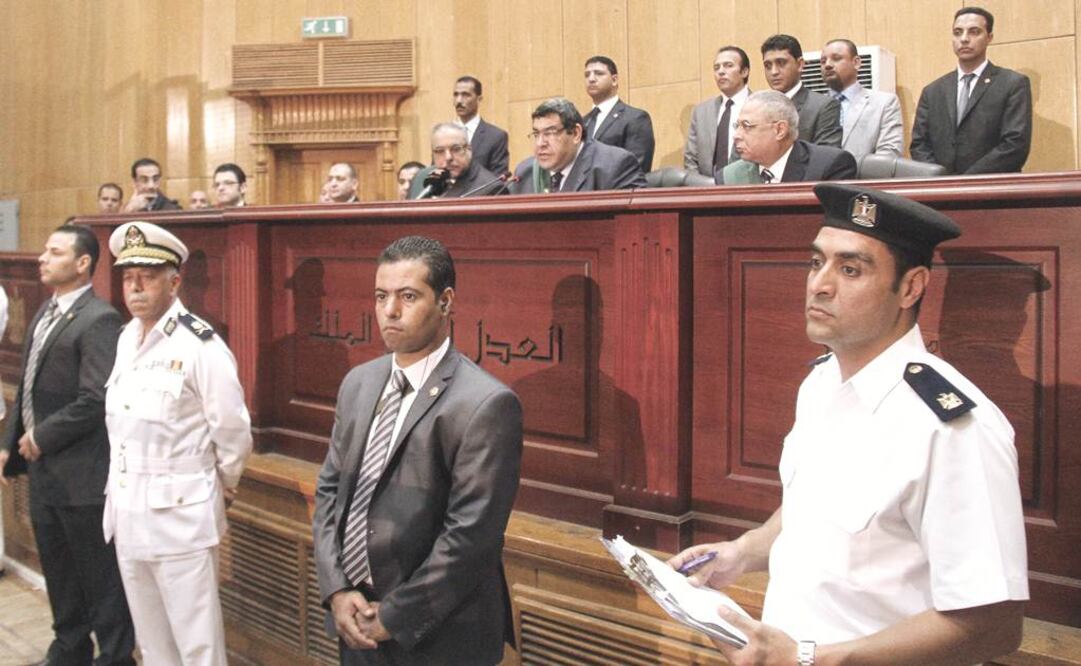 El juez Shaaban al-Shami, arriba, al centro, al sentenciar al ex mandatario Mohamed Mursi a pena de muerte, ayer, en las afueras de El Cairo. Otras 100 personas, incluido el líder de los Hermanos Musulmanes, Mohamed Badie, recibieron el mismo fallo.