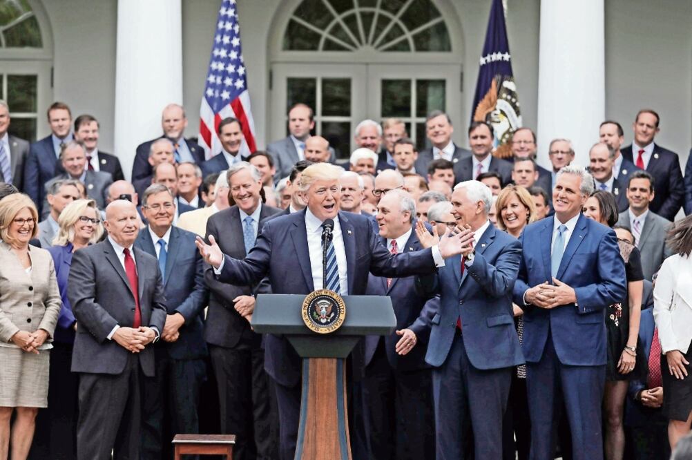 El presidente Donald Trump, con legisladores republicanos se toman la foto en el Jardín de las Rosas de la Casa Blanca, después de que la Cámara Baja aprobara una nueva reforma sanitaria. (CARLOS BARRIA. REUTERS)