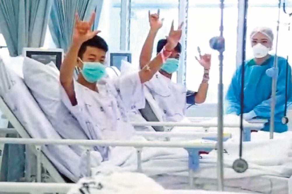 Dos de los niños rescatados de la cueva Tham Luang, en Tailandia, saludan desde el hospital,en la provincia de Chiang Rai, donde permanecen internados (EFE)