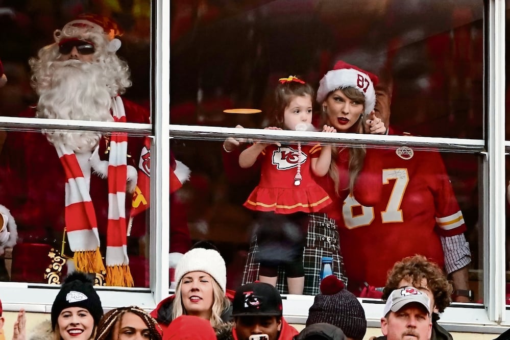 Taylor, vestida con los colores del equipo y acompañada de una pequeña fan, celebró con espíritu navideño en Kansas, mientras que Santa Claus y los aficionados mostraron su entusiasmo con actitudes y frases cómicas, como que ella mejoró a la NFL. Foto: AP
