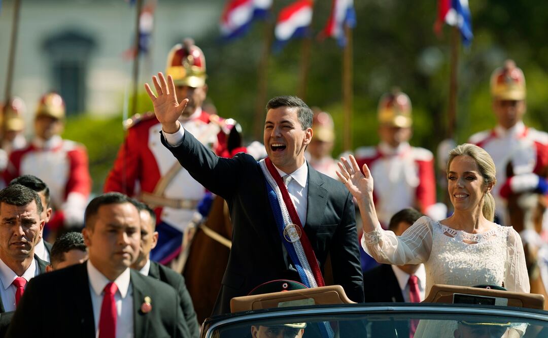 El nuevo presidente de Paraguay, Santiago Peña, y su esposa, Leticia Ocampos, saludan desde un automóvil mientras se dirigen a la Catedral el día de la asunción de Peña en Asunción, Paraguay. Foto: AP