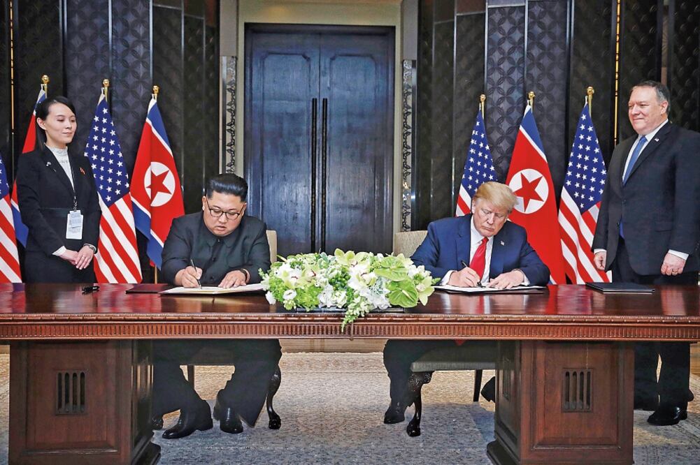 El líder de Corea del Norte, Kim Jong-un, y el presidente de EU, Donald Trump, al momento de firmar ayer una declaración conjunta tras la cumbre de Singapur. (XINHUA)