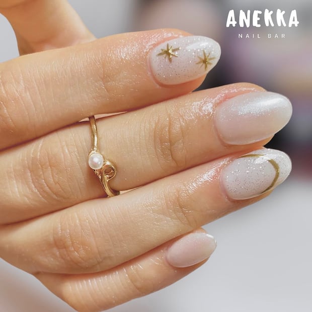 Acabado velvet en blanco Cloud Dancer con punta dorada y estrella metálica. Foto: Instagram @anekka.nails