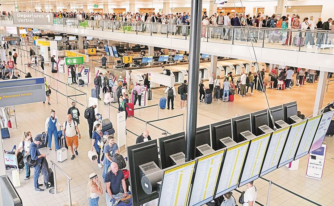 Los viajeros hacen largas filas para registrarse y abordar vuelos en el Aeropuerto de Ámsterdam-Schiphol, en Países Bajos. Foto: Peter Dejong/ AP.