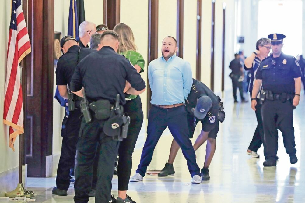 El consejal de la ciudad de Nueva York, Corey Johnson, grita consignas contra la reforma republicana de salud mientras es arrestado ayer en el edificio del Capitolio en Washington DC (MANUEL BALCE CENETA. AP)