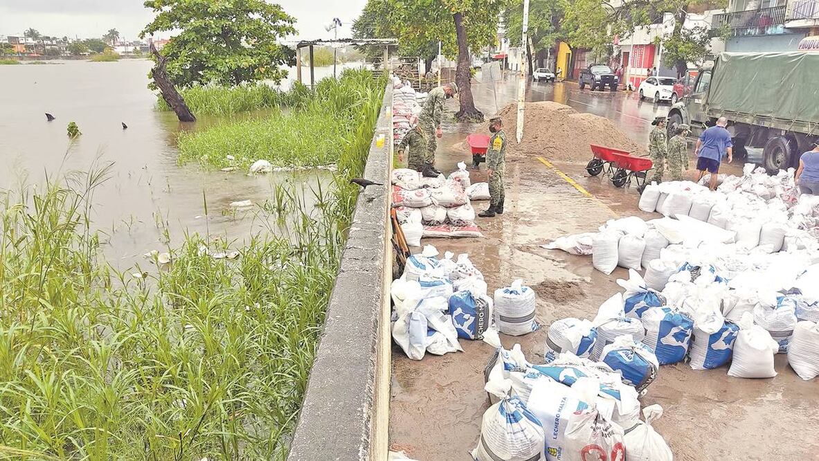 Elementos del Ejército y algunos pobladores colocan sacos de arena a la orilla del malecón para reforzarlo ante la crecida del cauce. Foto: Luma López. EL UNIVERSAL