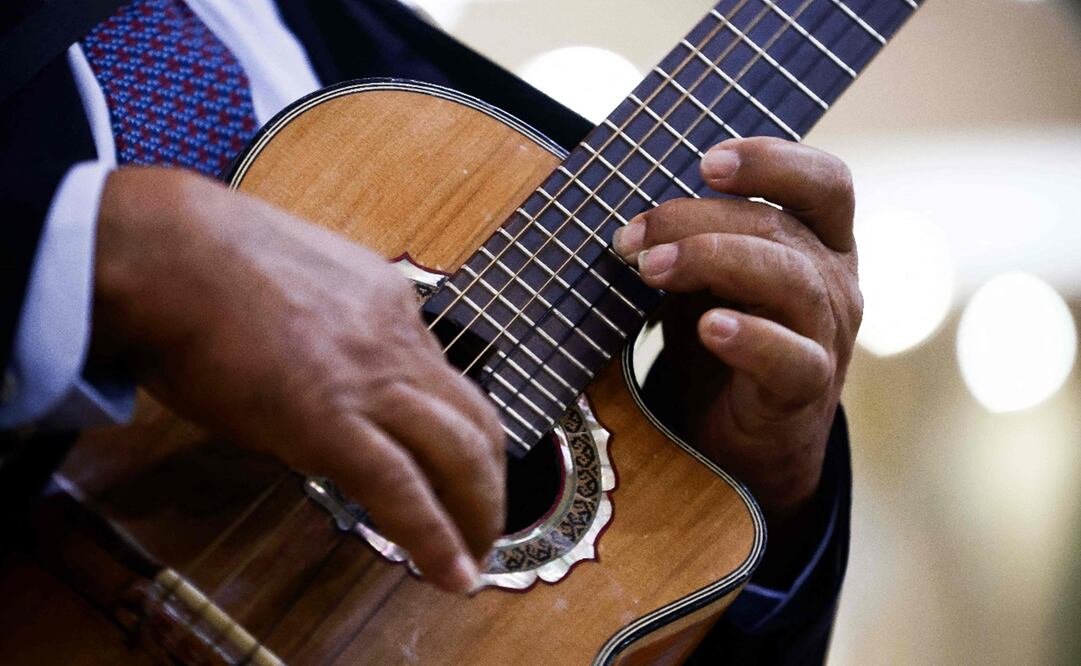 El cantante de bolero mexicano Cuitláhuac Díaz toca la guitarra en una cantina en la Ciudad de México el 4 de noviembre de 2023. Foto: Rodrigo Oropeza/AFP.