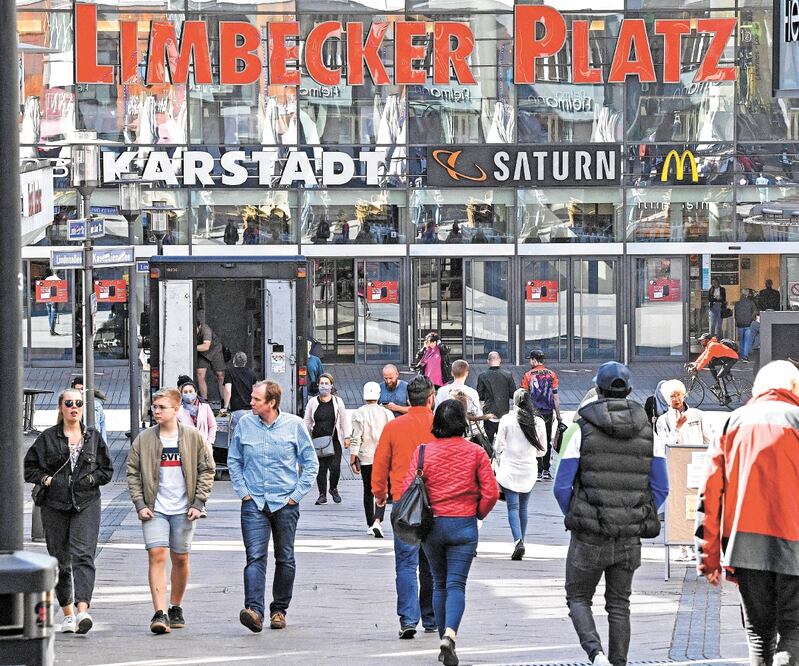 Ciudadanos caminan hacia un centro comercial, al reabrir algunas tiendas y fábricas en la localidad alemana de Essen. MARTIN MEISSNER. AP