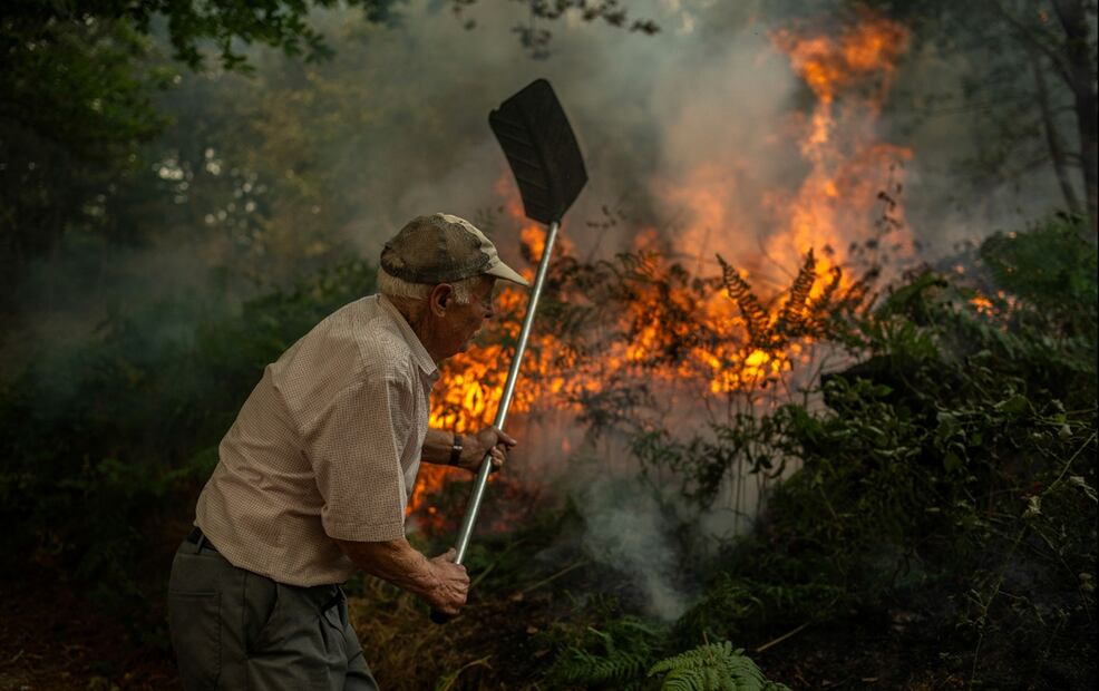 Una persona adulta de la aldea de Pareisás lucha contra el fuego del incendio forestal que permanece activo en A Pobra de Trives (Ourense), el 13 de agosto de 2025. Foto: EFE