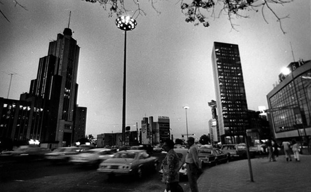 Una vista nocturna de los dos edificios de la Lotería Nacional, desde la esquina de la avenida Bucareli, a finales de 1979. Del lado izquierdo se encuentra el antiguo edificio de la Lotería Nacional, conocido como “El Moro”, cuando todavía tenía la antena en espiral en la parte superior; del derecho, la Torre Prisma, en la esquina del Paseo de la Reforma y la avenida Juárez. Crédito: Archivo El Universal