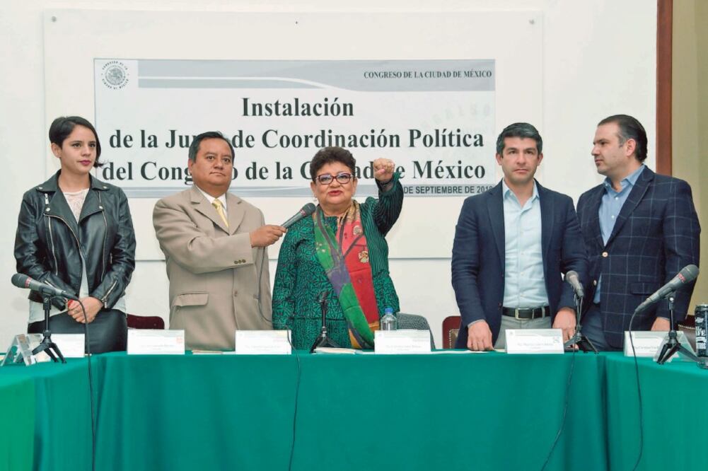 De pie y apuntalada por el vicecoordinador de Morena, Eduardo Santillán (segundo de izq. a der.), Ernestina Godoy (centro) rindió protesta como titular de la Junta de Coordinación Política del Congreso local. (ESPECIAL)