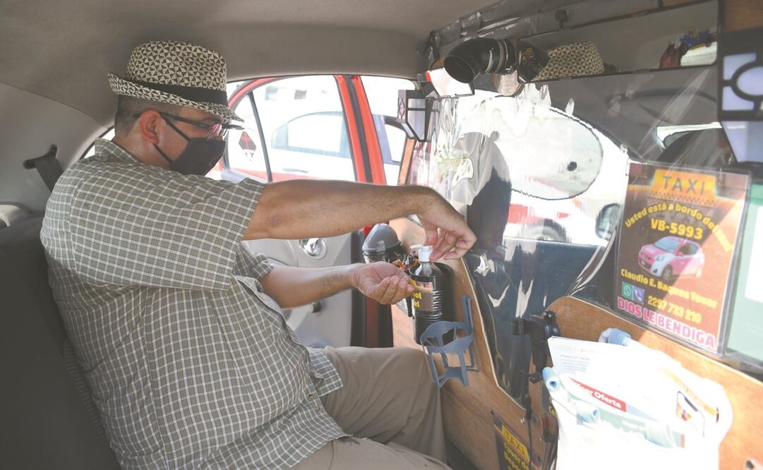 Claudio colocó a su taxi una mampara que divide en dos la unidad y dispensador de gel y caramelos. Fotos: Patricia Morales/ EL UNIVERSAL.