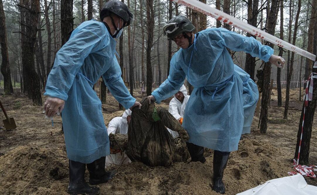 Servicios de emergencia exhuman un cuerpo de una de las tumbas localizadas cerca de Izium, en Kharkiv, Ucrania. Foto: Evgeniy Maloletka/AP