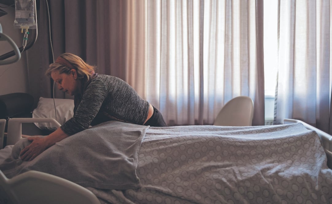 Una cuidadora con una ciudadana francesa que padece hemiplejia y ceguera de nacimiento debido a un ictus perinatal, tras el proceso de eutanasia en un hospital belga. En Bélgica y Holanda todos los ciudadanos están obligados a contratar un seguro de cobertura de enfermedad. Foto: Simon Wohlfahrt/ AFP