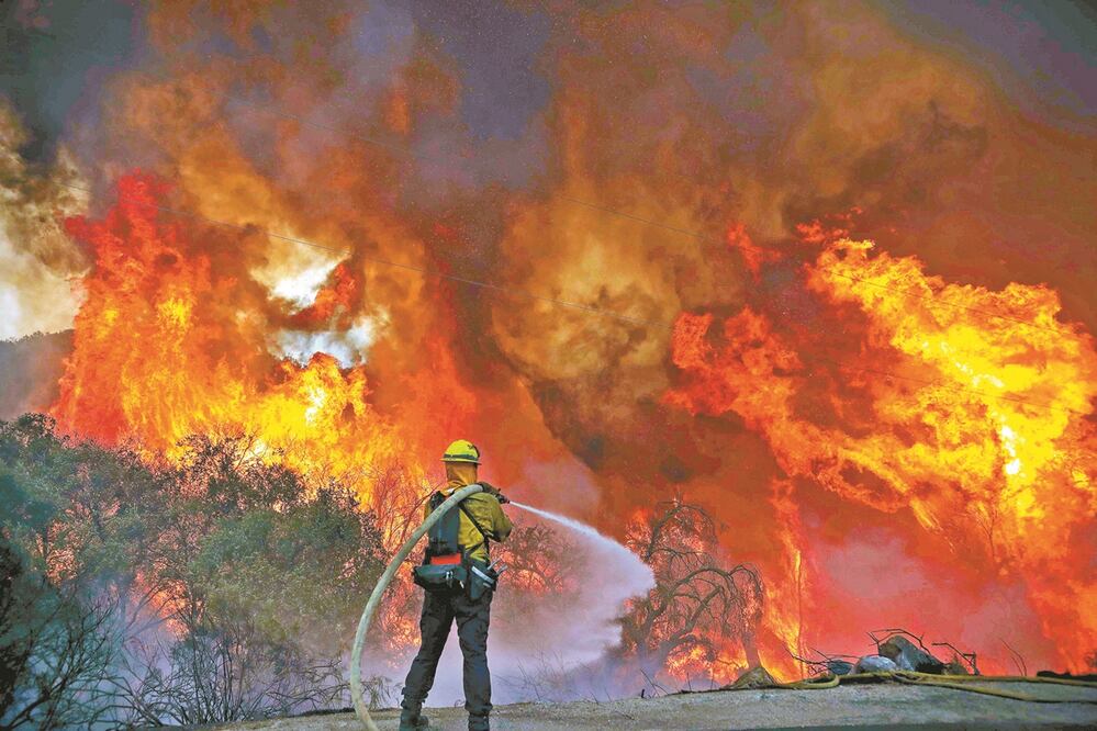 Bomberos del condado de San Miguel combatían ayer las llamas del incendio Valley, uno de tres desatados en California. Foto: SANDY HUFFAKER. AFP