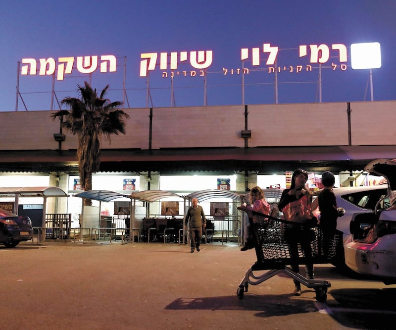 Personas afuera de un supermercado en el asentamiento israelí de Mishor Adumin. La ONU identificó a 112 empresas ligadas a los territorios ocupados. Foto: AMMAR AWAD. REUTERS