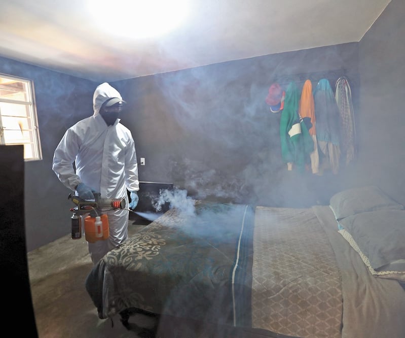Enfundado en un traje impermeable para protegerse, Evodio limpia una casa donde murió una persona por Covid-19. Foto: JORGE ALVARADO. EL UNIVERSAL