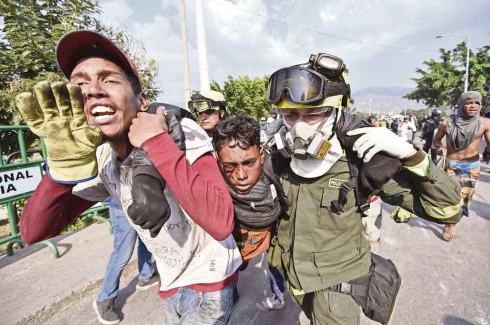 Un manifestante recibe asistencia en el Puente Simón Bolívar, en Cúcuta, Colo m b ia , tras ser herido en los enfrentamientos en San Antonio del Táchira, Venezuela. (LUIS ROBAYO. AFP)