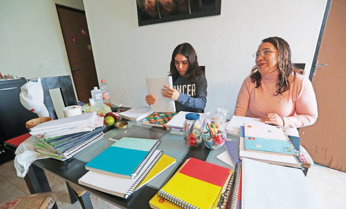 Karen y su mamá crean “nuevos cuadernos” con hojas sobrantes y los forran con cartulinas de colores, también recicladas. Foto: Jorge Alvarado / El Universal