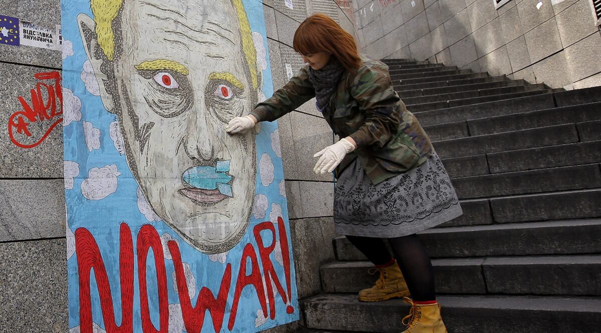 Una estudiante de arte ucraniana retoca un cartel que representa al presidente ruso, Vladímir Putin. Imagen ilustrativa. Foto: EFE/Robert Ghement, archivo