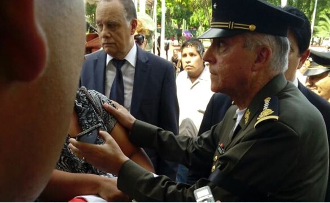 El general secretario, Salvador Cienfuegos, comunica por celular al Presidente de la República con la esposa de uno de los soldados asesinados. /Javier Garduño - EL UNIVERSAL