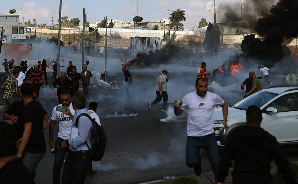 Los palestinos se dispersan durante los enfrentamientos con los soldados israelíes en la entrada norte de la ciudad palestina de Ramallah, cerca del asentamiento judío de Beit El, en la Cisjordania ocupada, el 13 de octubre de 2023. Foto: AFP