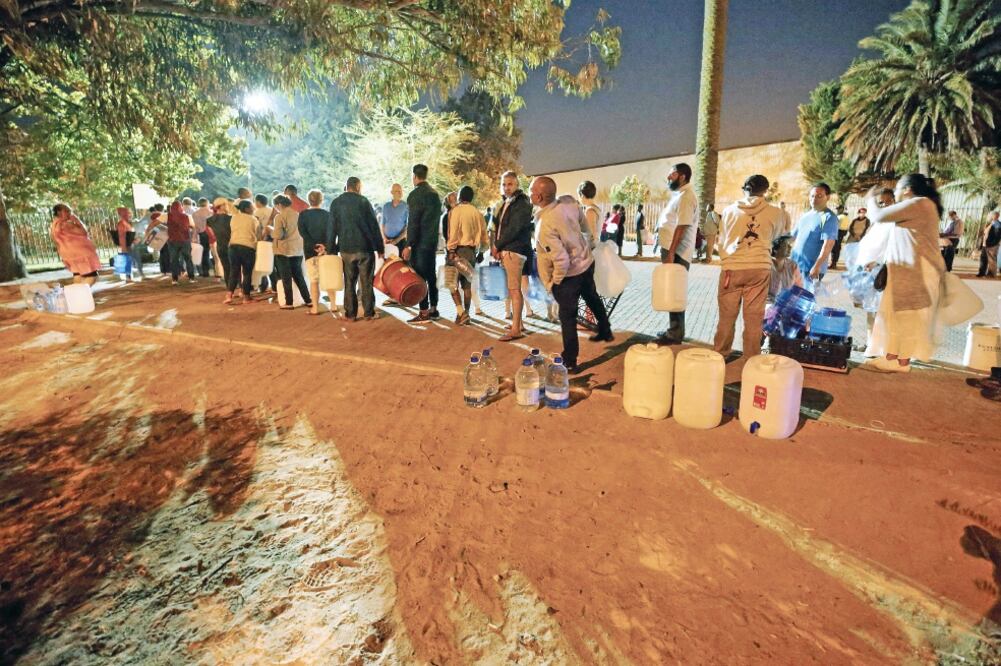 Personas hacen fila para obtener agua en Ciudad del Cabo. Habitantes dicen que mucha gente rica sigue regando sus jardines y llenando sus albercas, porque como tienen dinero piensan que la crisis no aplica para ellos (MIKE HUTCHINGS. REUTERS)
